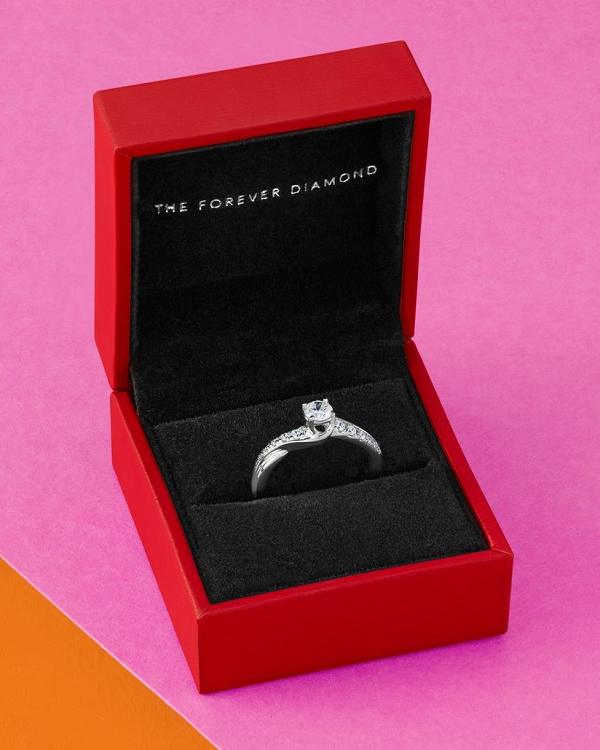 A diamond ring in a plush red ring box