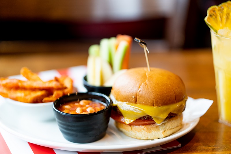 A kids meal- a small cheeseburger and pot of beans