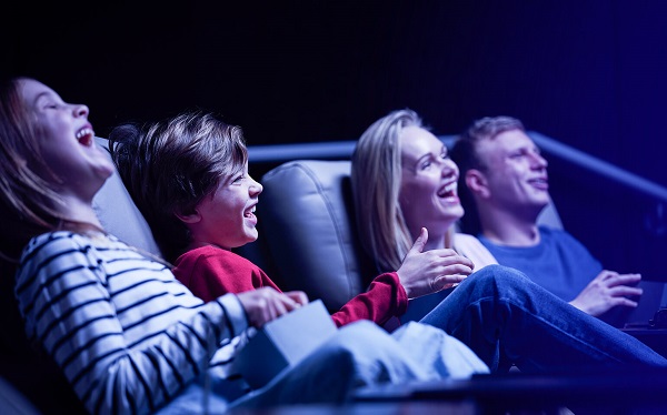 A group or family watching a film in a cinema and laughing